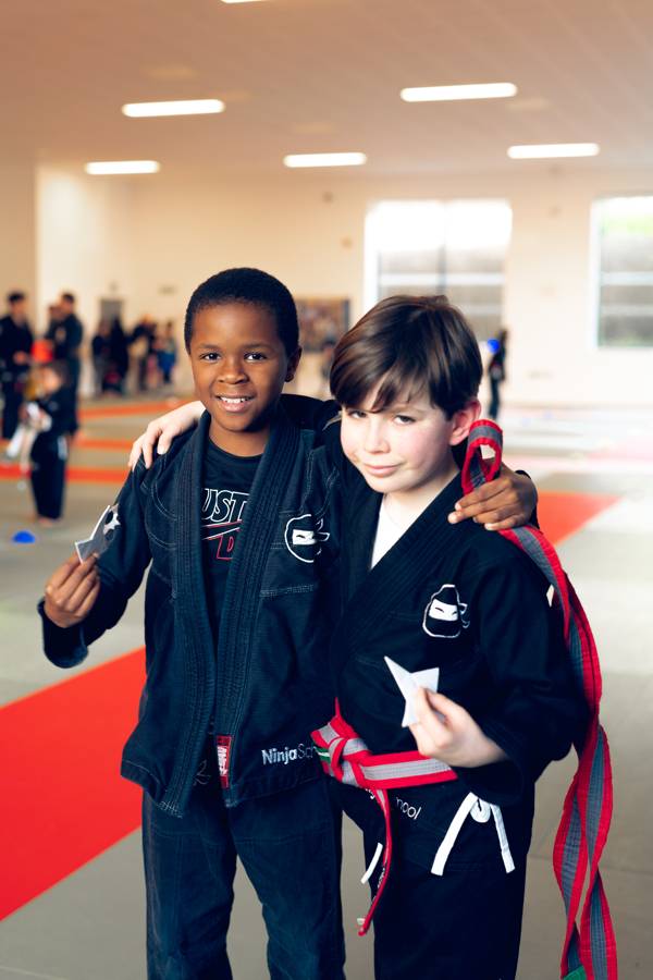 Two Ninja School students, arms around each other, smiling after class