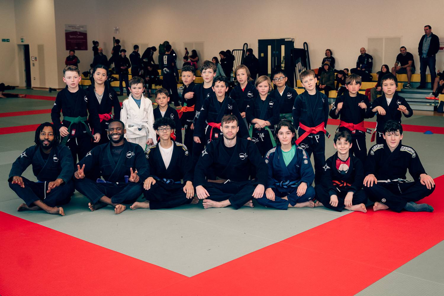 Students and instructors gathered together on the mats