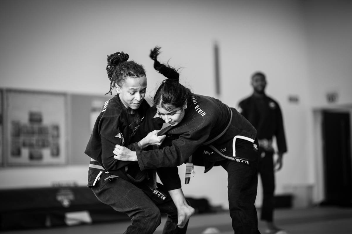 Two Kaizen students grappling, in black and white